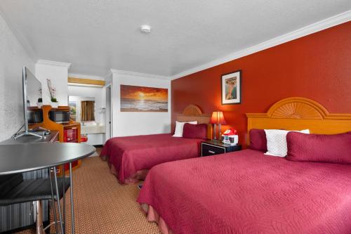 南旧金山阿美莉卡那汽车旅馆的酒店客房,设有两张带红色墙壁的床