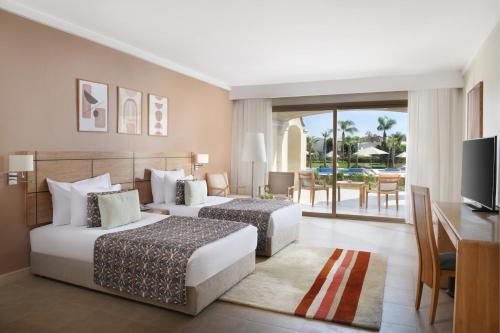 艾因苏赫纳小威尼斯高尔夫杰斯酒店&度假村的酒店客房设有两张床、一张桌子和一台电视。