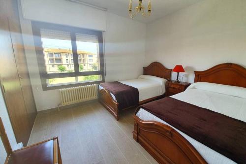 RodeznoLa Casita de Irene的酒店客房设有两张床和窗户。