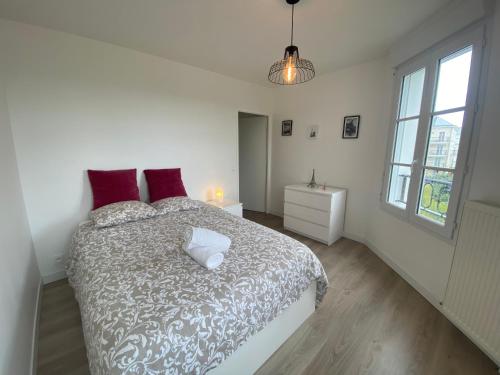 塞里斯T4 Disney Paris/Val d’Europe的白色卧室配有一张带红色枕头的大床