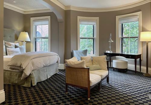波士顿Clarendon Square的一间卧室配有一张床、一把椅子和一架钢琴