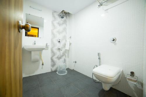 班加罗尔Hotel Plaza Heights的白色的浴室设有卫生间和水槽。