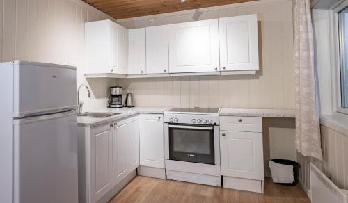 利勒哈默尔Lillehammer Camping的白色的厨房配有白色橱柜和冰箱。