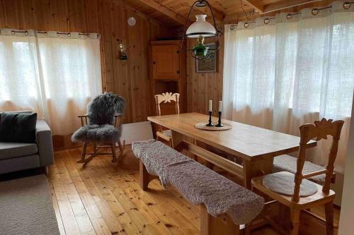 奥普达尔Charming Mountain Cabin的一间带木桌和椅子的用餐室