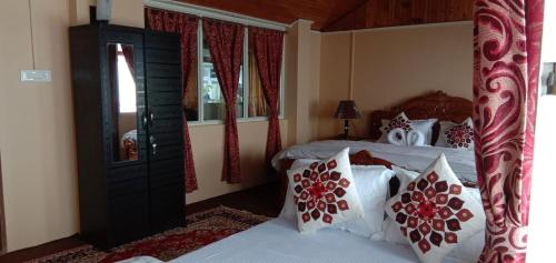 大吉岭RISE N SHINE HOMESTAY的一间卧室配有带白色和红色枕头的床
