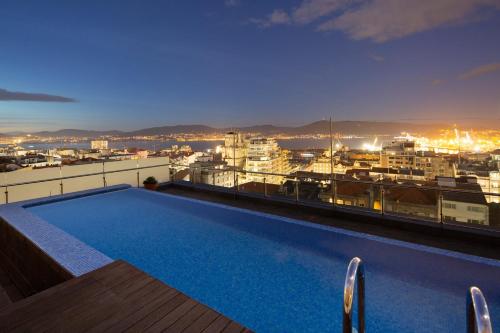 维戈Silken Axis Vigo的建筑物屋顶上的游泳池