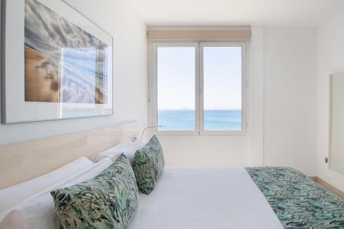 普拉亚布兰卡Blancazul Marina的白色的卧室设有床和窗户