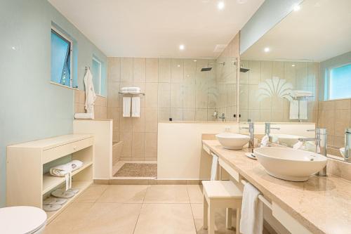 塔马林多伊甸园精品酒店的一间带两个盥洗盆和淋浴的浴室
