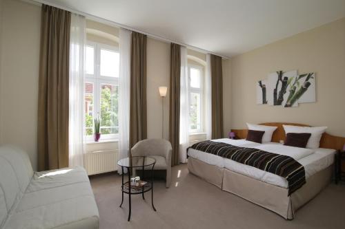 贝利茨Gut Hotel Stadt Beelitz的配有一张床和一把椅子的酒店客房