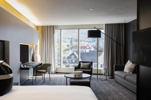 开普敦The Capital 15 on Orange Hotel & Spa的酒店客房设有一张床和一个大窗户