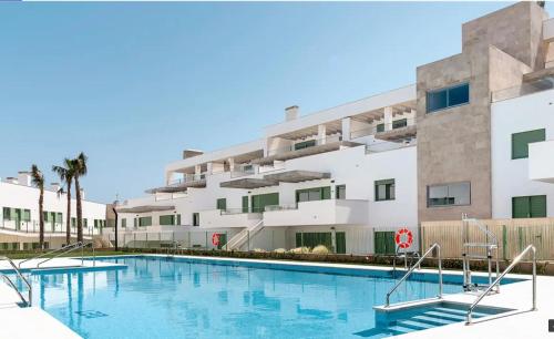 莫哈卡尔OCEAN APARTAMENT !! 1ª Línea del Mar, piscina, parking, wifi的大楼前的游泳池