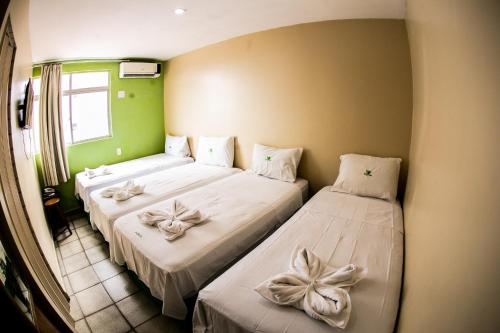 若昂佩索阿Cidade Verde Flat Hotel的配有弓的客房内的两张床