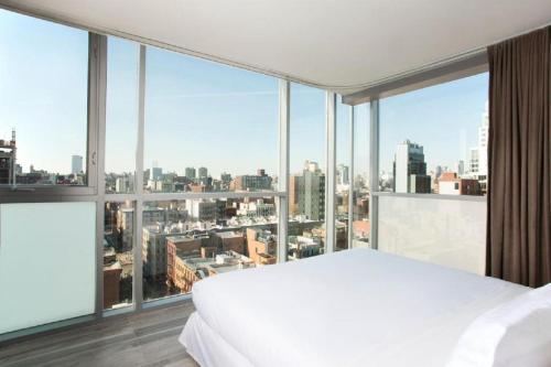纽约利文顿酒店的卧室设有白色的床和大窗户