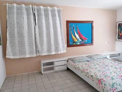 考卡亚Villa Oloh com lazer completo em Caucaia - CE的卧室配有一张床,墙上挂有绘画作品