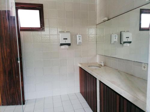 考卡亚Villa Oloh com lazer completo em Caucaia - CE的白色瓷砖浴室设有水槽和窗户