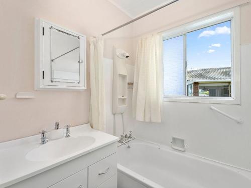 陶波Central Riverside Retreat - Taupo Holiday Home的白色的浴室设有水槽和窗户。