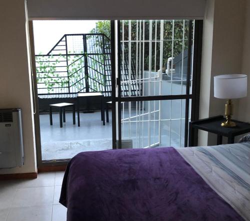 圣卡洛斯-德巴里洛切Departamento Céntrico Bariloche con patio的一间卧室设有一张床,享有阳台的景色