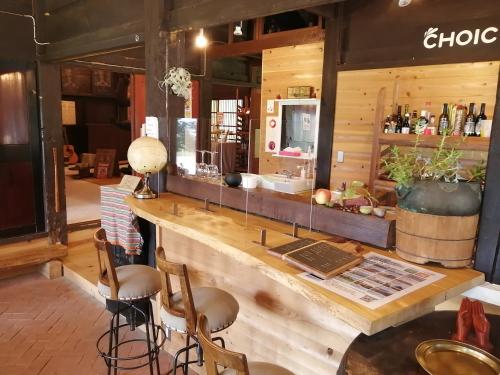 南砺Guesthouse Kazura的餐厅内的酒吧,带柜台和凳子