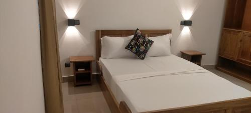 洛美AZURIA HOTEL的卧室配有白色的床和2个枕头