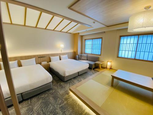 大阪IAM HOTEL的客房设有两张床、一张桌子和窗户。