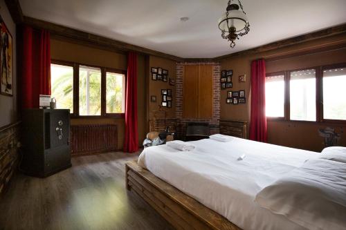 贝坦索斯La Casona de Betanzos的一间卧室配有大床和红色窗帘