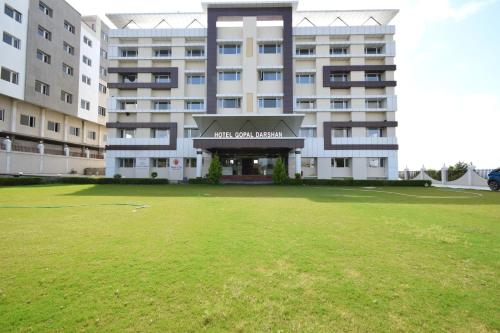 纳特杜瓦拉The Sky Imperial- Hotel Gopal Darshan的前面有大草坪的大建筑