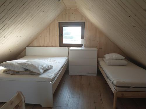 格但斯克多梅科维斯皮山林小屋的阁楼卧室设有两张床和窗户。