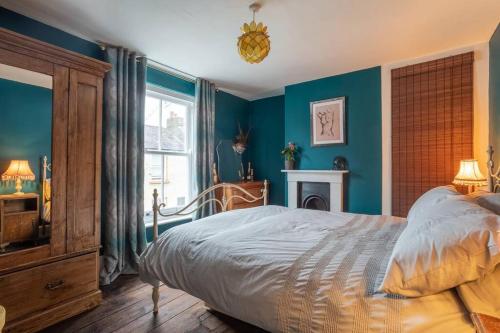 剑桥Lovely Central Cambridge Home的一间拥有蓝色墙壁的卧室、一张床和窗户