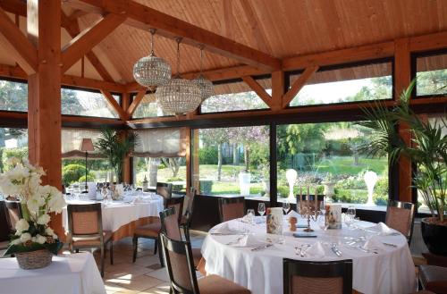 Saint-Jean-aux-Bois奥博热拉邦内伊德酒店的一间设有白色桌椅和窗户的用餐室