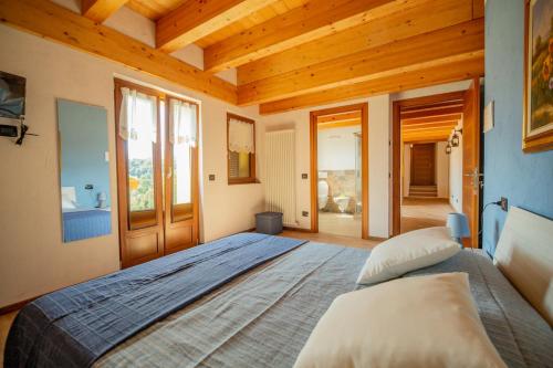 圣费德勒·因特尔维Agriturismo La Cascina B&B的一间带一张大床的卧室,位于一个拥有木制天花板的房间