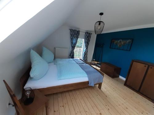 蒙绍Ferienhaus Wiesenblick的一间卧室配有一张蓝色墙壁的床和一扇窗户
