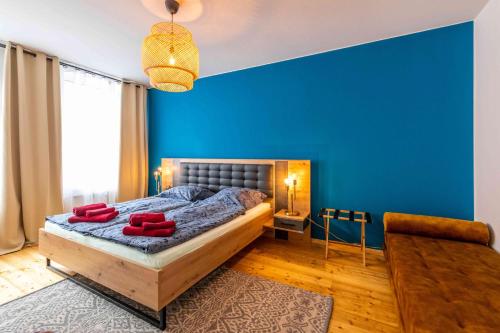 莱比锡Großer Terrassentraum in Klein Venedig的一间拥有蓝色墙壁的卧室和一张带红色枕头的床