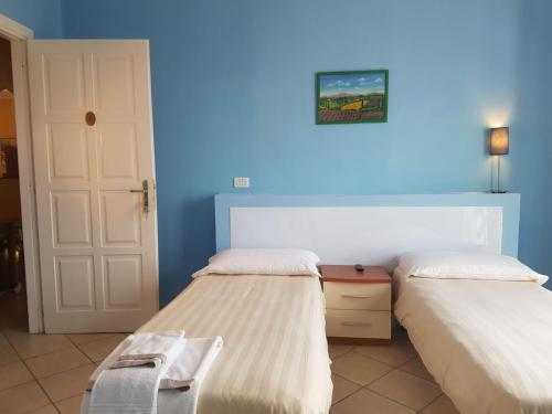 布拉Hotel The Marins的一间卧室设有两张床和蓝色的墙壁