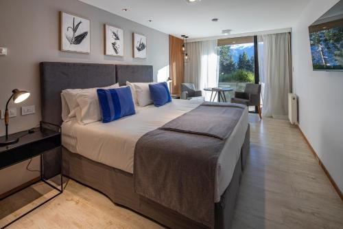 特拉福镇Hotel Alto Traful的一间卧室配有一张带蓝色枕头的大床