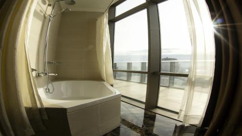 巴库Parkside Hotel & Apartments的带浴缸的浴室和窗户。