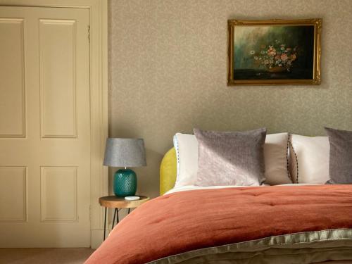 布莱尔高里Heathpark House的一间卧室配有一张带橙色毯子和灯的床