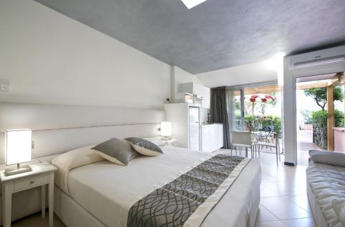 因佩里亚Villa Giada Resort的一间带大床的卧室和一个阳台