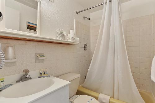 威尔伍德克拉斯特格拉纳达海洋度假胜地汽车旅馆的浴室配有白色的浴帘和卫生间