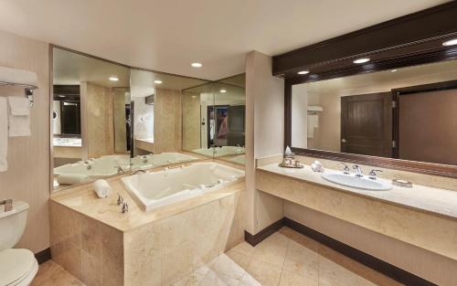 拉斯维加斯Treasure Island - TI Las Vegas Hotel & Casino, a Radisson Hotel的带浴缸、两个盥洗盆和卫生间的浴室