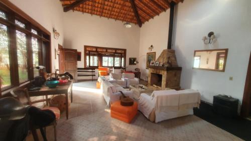 帕蒂杜阿尔费里斯Pousada das Casuarinas的客厅配有白色沙发和壁炉