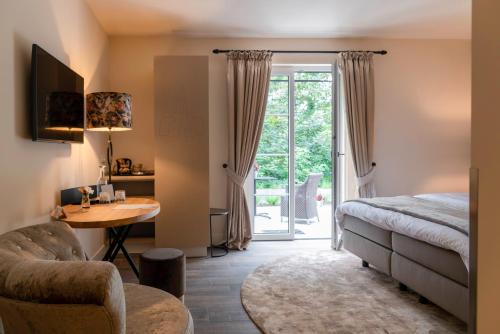 比尔弗利特KerkHotel Biervliet的一间卧室配有一张床、一张桌子和一张桌子