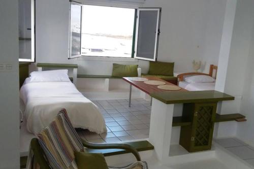 奥尔索拉Apartamentos Los Vientos (Apto 8)的一间卧室配有一张床、一张桌子和一张沙发