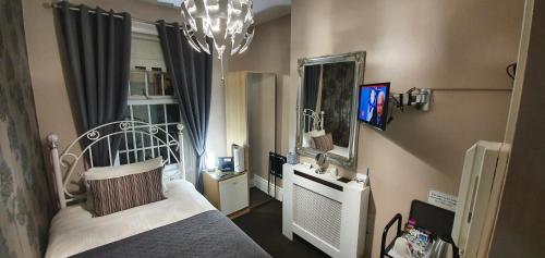 南希尔兹比奇伍德酒店的一间卧室配有一张床、镜子和吊灯