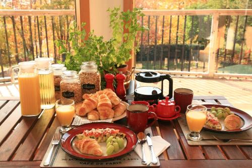 Fall RiverThe Burgundy Dream Bed And Breakfast的一张桌子,早餐包括羊角面包和橙汁