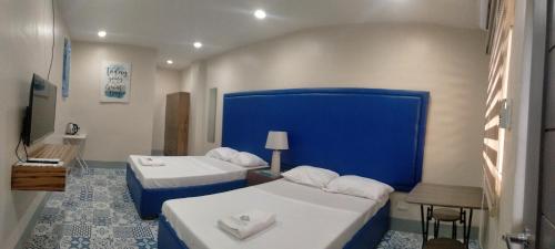 独鲁万Athena's Guest House的酒店客房设有两张床和蓝色的墙壁。