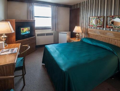 温尼伯柯蒂斯戈登汽车旅馆的酒店客房,配有床和电视