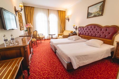吉格涅斯科斐耶Casino & Hotel ADMIRAL Skofije的酒店客房,设有两张床,铺有红地毯。