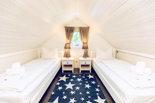 博尔滕哈根Regenbogen Boltenhagen的阁楼间配有2张床和1张美国国旗地毯