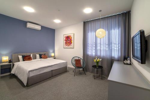 埃里温Benefice Hotel Yerevan的一间卧室配有一张床、一张桌子和一台电视。