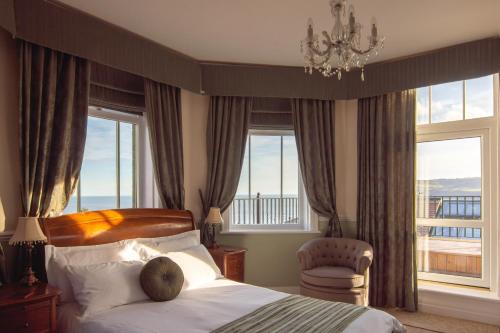 惠特比维多利亚酒店的一间卧室配有一张床、吊灯和窗户。
